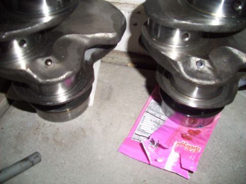 1995 Ford Probe - Close-up view of engine crankshafts, with a snack bag visible beneath one of them.