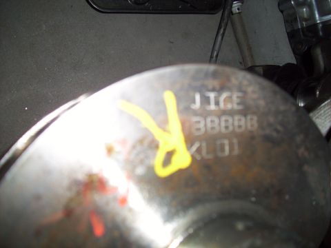 1995 Ford Probe - Close-up of a metal part showing stamped alphanumeric markings and a yellow painted symbol.