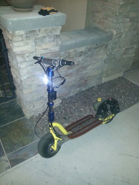 1978 Ford Bronco - A gas-powered scooter with a yellow frame and wooden deck is parked outdoors.
