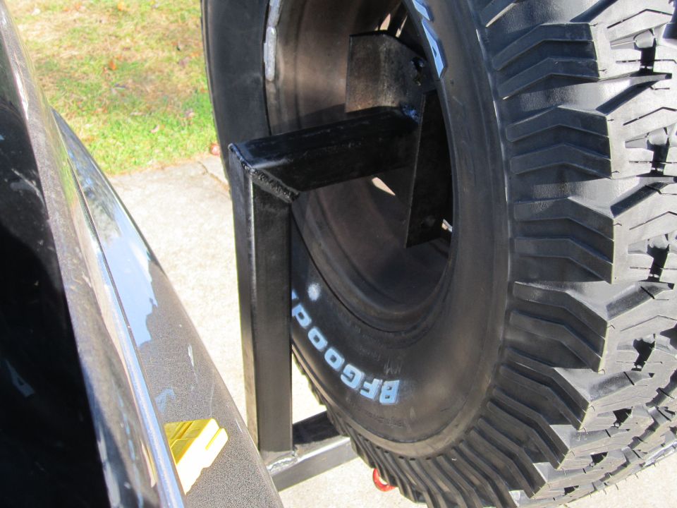 BFGoodrich spare tire mounted on a black metal bracket attached to a vehicle's body panel