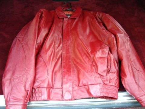 1994 Ford Bronco - A red leather jacket is displayed against a red textured background.