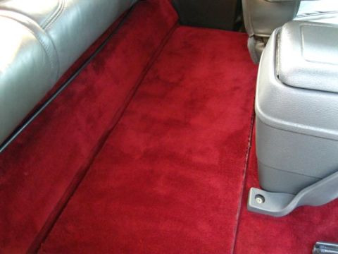 1994 Ford Bronco - Interior view of red carpet and center console in a vehicle.