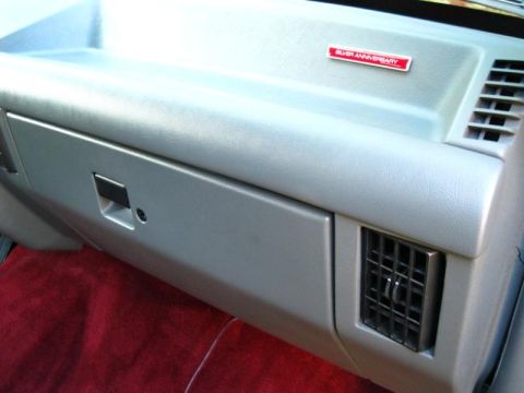 1994 Ford Bronco - A close-up view of a vehicle's interior dashboard, a glove compartment and an air vent.