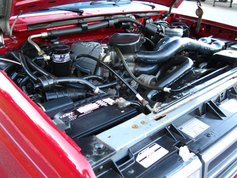 Red engine bay with visible battery and hoses