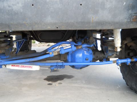 1992 Ford Bronco - Undercarriage view showing blue-painted suspension parts and a Rough Country shock absorber. The registry claims this is a 1992 Ford Bronco.