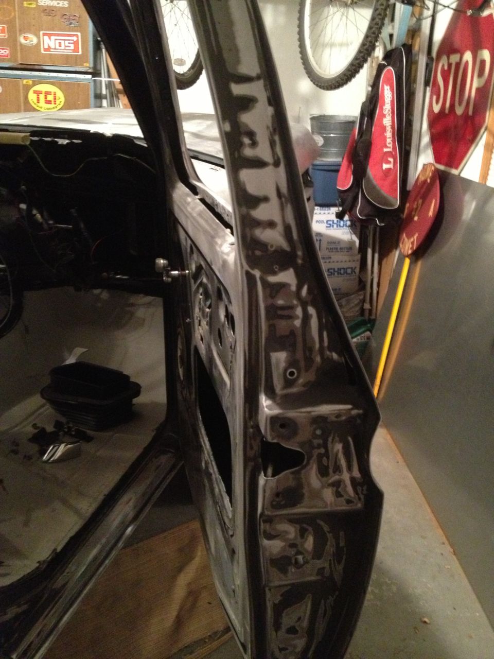 Open car door frame, showing interior structure and some tools on the floor