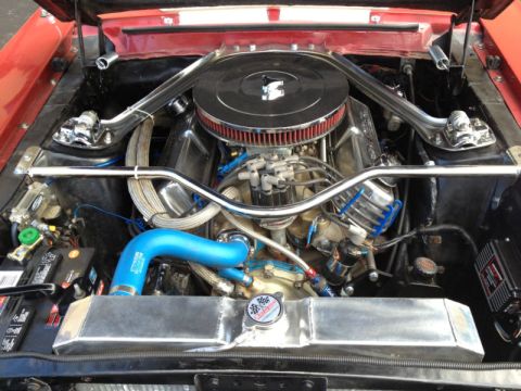 1968 Ford Mustang - Customized V8 engine bay, possibly from a 1968 Ford Mustang, with chrome accents and blue hoses.