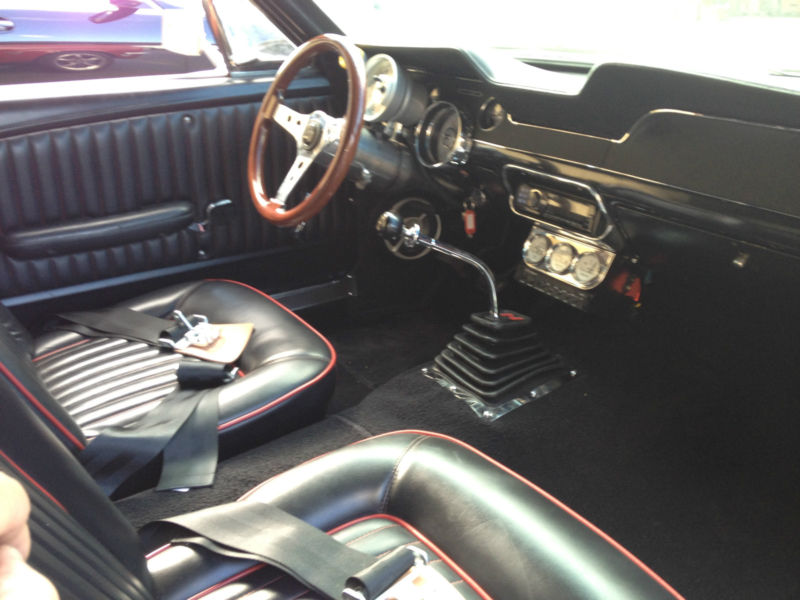 1968 Ford Mustang interior with black seats and wood steering wheel