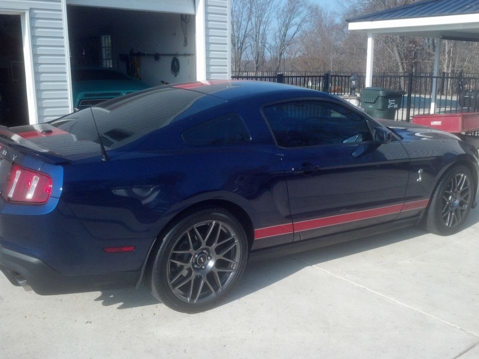 Blue Ford Shelby GT500 Mustang coupe with red stripes in driveway