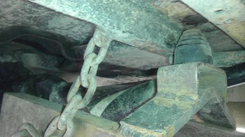 1989 Ford Bronco - The undercarriage of a 1989 Ford Bronco shows a chain connected to the frame, suggesting a modification or repair.
