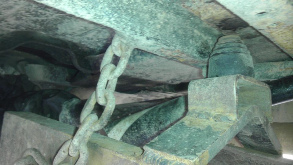 Undercarriage of a 1989 Ford Bronco with a chain attached to the frame
