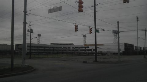 1989 Ford Bronco - A wide shot of a large building complex under a cloudy sky, with traffic lights and utility poles in the foreground.