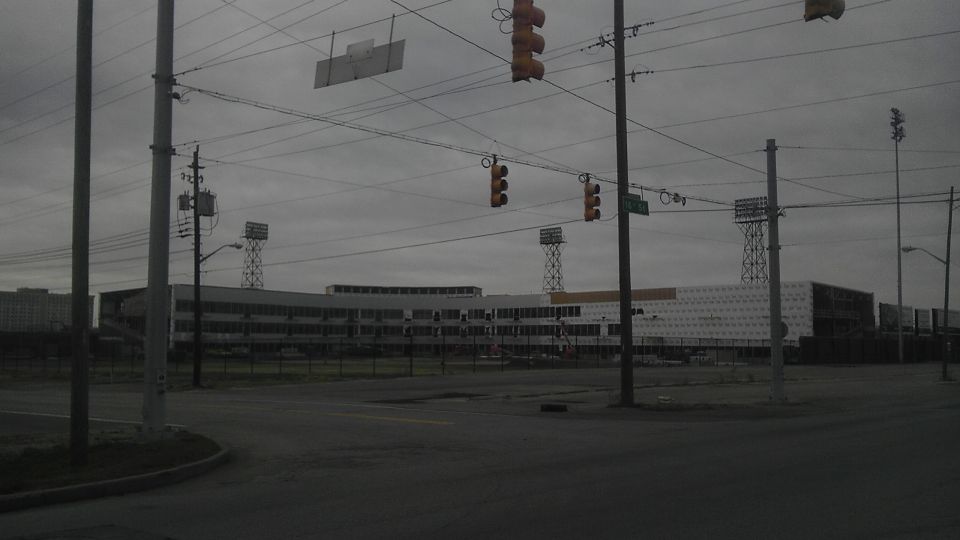 Overcast sky over a large building with stadium lights