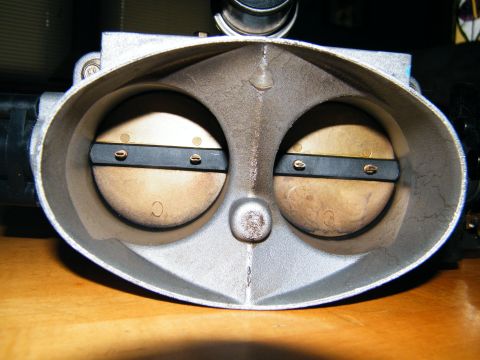 2004 Ford Crown Victoria - Dual throttle body interior view showing two butterfly valves and mounting screws.