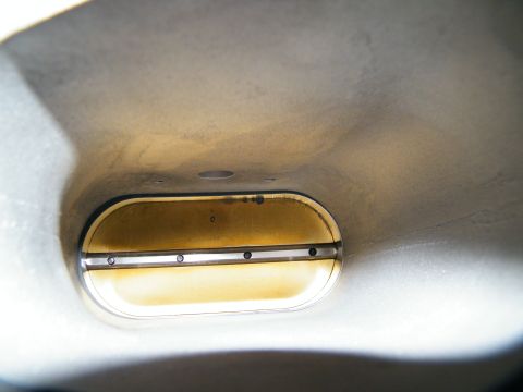 2004 Ford Crown Victoria - Close-up view of a throttle body's internal components, showing a brass plate and fasteners.