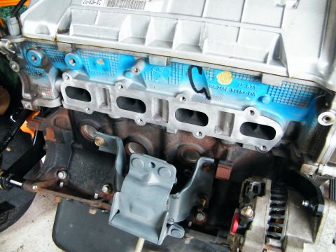 2004 Ford Crown Victoria - Detail of a 2004 Ford engine component, showing blue painted sections and stamped identification numbers.