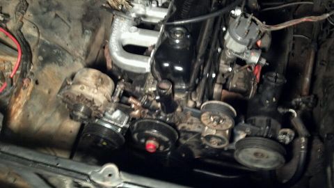 1978 Ford Bronco - Close-up view of an engine bay an inline-six engine and various accessories, including the alternator and power steering pump.