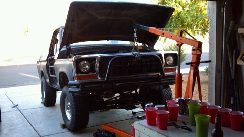 1978 Ford Bronco - Front view of a 1979 Ford truck with its hood up, being worked on with an engine hoist.