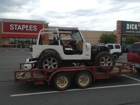 2000 Jeep Wrangler - A white 2000 Jeep TJ is seen on a trailer in a parking lot, with Staples and Dick's Sporting Goods in the background.