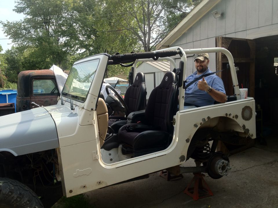 White 2000 Jeep TJ with bodywork in progress, man giving thumbs up