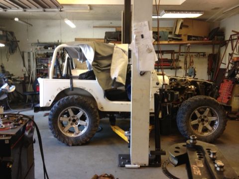 2000 Jeep Wrangler - White Jeep TJ in a garage, undergoing some work with the hood removed.