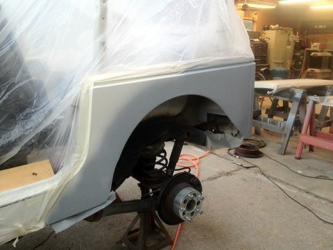 2000 Jeep TJ - The rear quarter panel of a vehicle is being prepped for paint in a workshop setting.