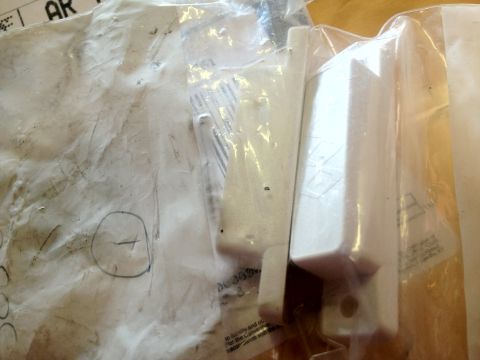 2000 Jeep TJ - Unidentified white plastic car parts are shown in their original packaging.