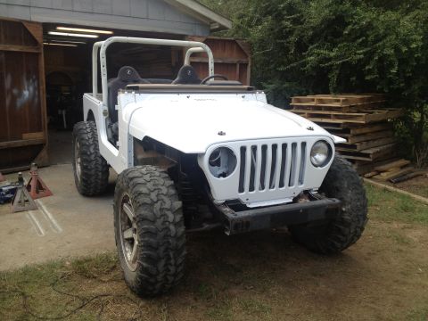 2000 Jeep TJ - White Jeep TJ, likely a 2000 model, is undergoing modifications in a garage setting.