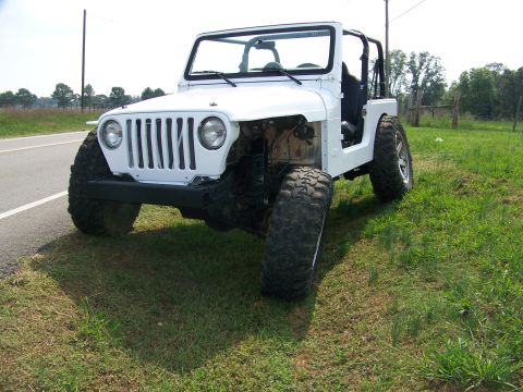 2000 Jeep Wrangler - This white Jeep TJ is missing its front fenders, revealing its engine bay and suspension components.