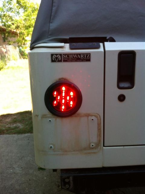 2000 Jeep TJ - Close-up of a Jeep's rear quarter panel, showing a red LED tail light and a manufacturer's badge.