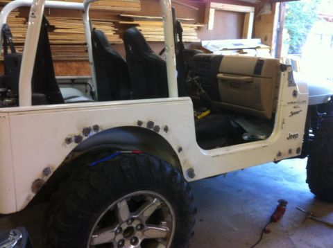 2000 Jeep TJ - This 2000 Jeep TJ shows interior details and evidence of bodywork repairs on the rear fender and rocker panel.