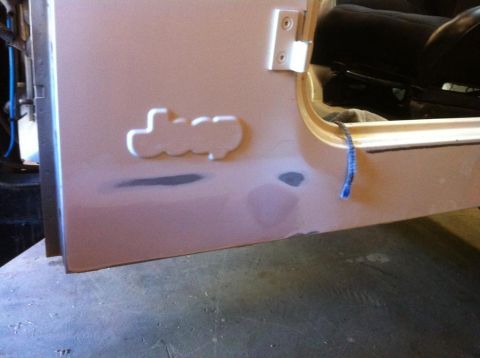 2000 Jeep TJ - Close-up of a Jeep door panel showing the emblem and preparation for paint.