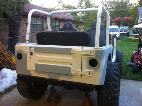 2000 Jeep TJ - Rear view of a 2000 Jeep TJ with a custom roll cage and seats, supported by jack stands.