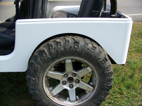 2000 Jeep Wrangler - This Jeep features large off-road tires and aftermarket wheels, with a white body and black interior seats visible.