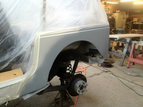 2000 Jeep TJ - A Jeep TJ's rear fender and suspension are visible while undergoing body work in a garage.