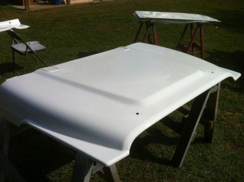 2000 Jeep TJ - A white Jeep hood is prepped for paint, supported by sawhorses in a grassy yard.