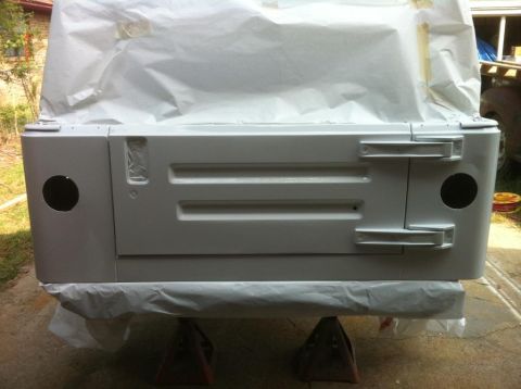 2000 Jeep TJ - The rear panel of a Jeep is covered in masking paper and resting on jack stands, ready for body work.