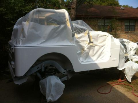 2000 Jeep TJ - This Jeep TJ is covered in protective materials, indicating it is undergoing preparation for a paint job.