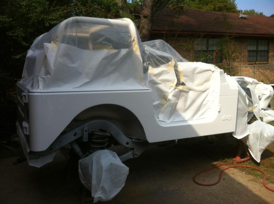 Side view of white Jeep TJ covered in plastic and tape for painting