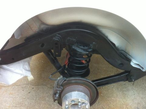 2000 Jeep TJ - Close-up view of the suspension system and fender well of a Jeep TJ, showing the coil spring and brake components.