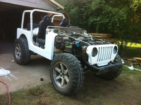 2000 Jeep TJ - A white Jeep TJ is parked outside with its hood open, revealing the engine and aftermarket wheels.