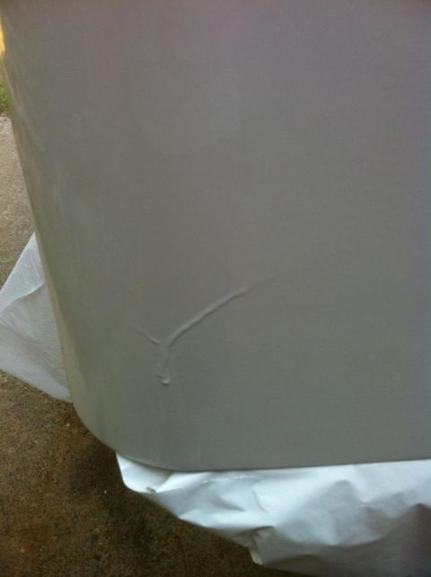 2000 Jeep TJ - Close-up of a damaged gray car door panel showing a crack and paint imperfections.