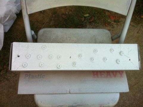 2000 Jeep TJ - A white metal part with many screws is placed on top of a cooler.