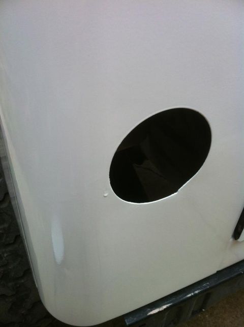 2000 Jeep TJ - Close-up of a white Jeep body panel showing a circular cutout and a small paint drip.