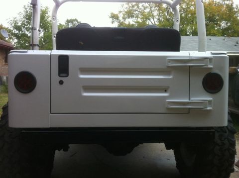 2000 Jeep TJ - The rear of a white Jeep is shown, a white hardtop and roll cage.