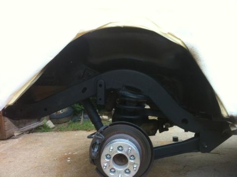 2000 Jeep TJ - Close-up view of the rear wheel well and suspension system, with the fender area covered.