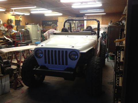 2000 Jeep TJ - A white Jeep Wrangler is parked inside a cluttered garage with a person visible in the background.