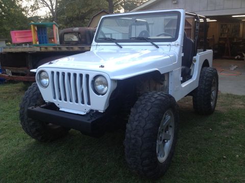 2000 Jeep TJ - White Jeep TJ with large tires and aftermarket bumper, parked outdoors.