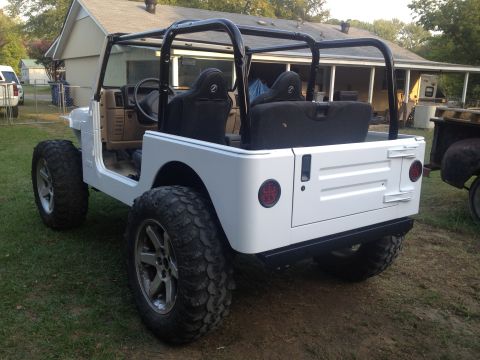 2000 Jeep TJ - This white Jeep Wrangler features a black roll cage and aftermarket wheels, viewed from the rear.