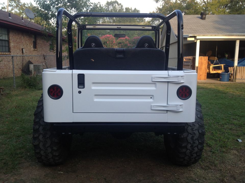 White Jeep TJ rear view with roll cage and black seats